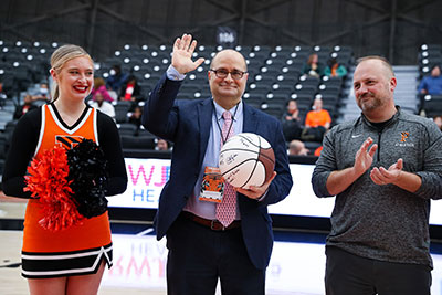 Dr. Eladoumikdachi standing on the Princeton basketball court, Dr. Eladoumikdachi is holding a basketball and waving